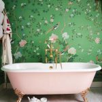 a girlish space with green and pink floral print wallpaper and a blush  bathtub for a