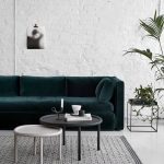 Dark Green Velvet Sofa against White Brick Wall