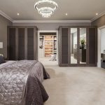 This bedroom features opulent, padded doors and headboards combined with  the warm, contemporary Anthracite Larch finish.