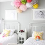 A pair of little ladies sleep side by side in this lovely set up, complete  with a colorful floral decoration that lives right in the middle.