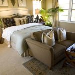 At the foot of the bed is a low-profile corduroy loveseat with a small