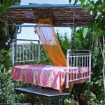 Hanging outdoor bed with wooden sunshade and light curtain