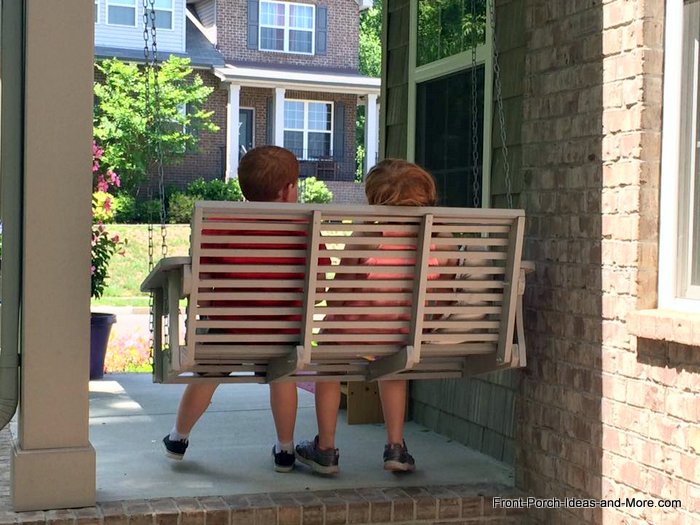 Children making memories on front porch swing