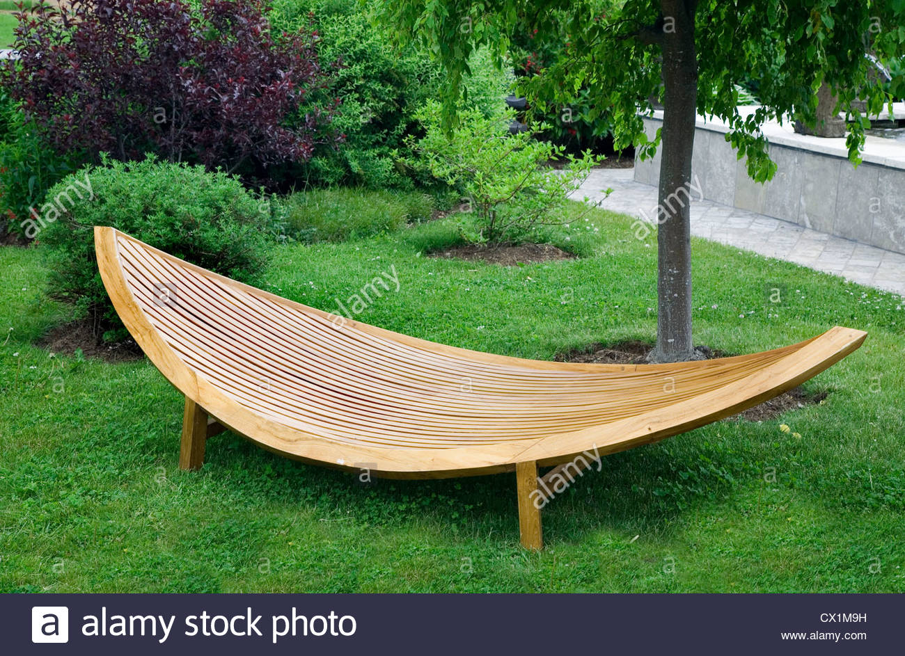 Sleek modern garden furniture made of wood and varnished. - Stock Image
